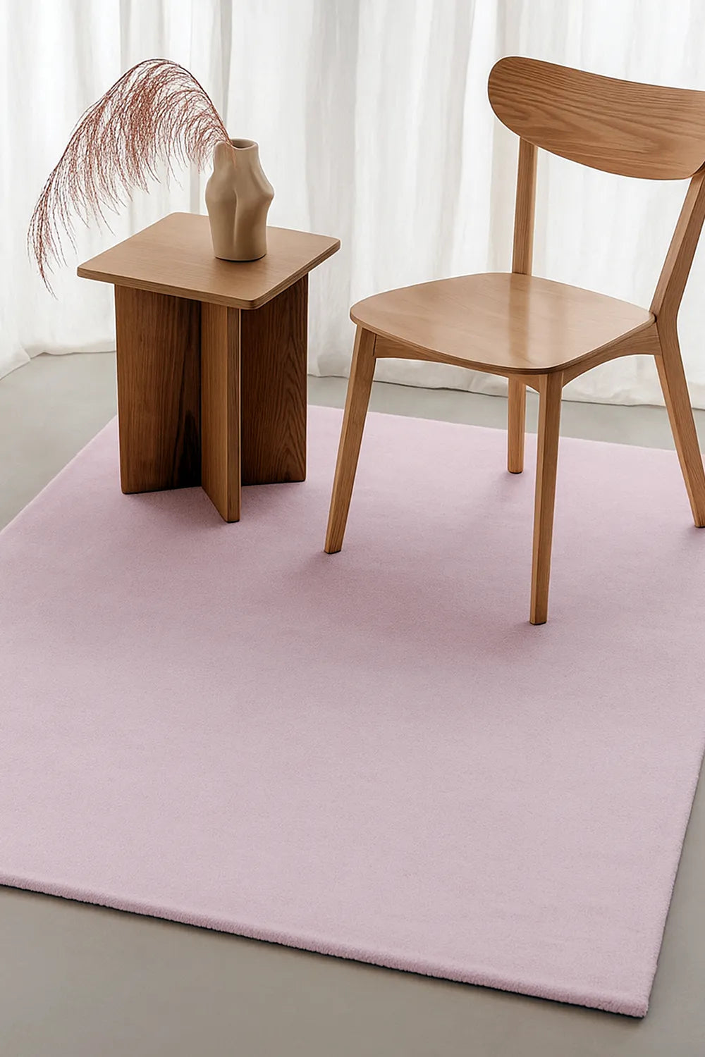 Blush pink hand-tufted wool rug styled with natural wood furniture, ideal for modern dining rooms and cozy living spaces