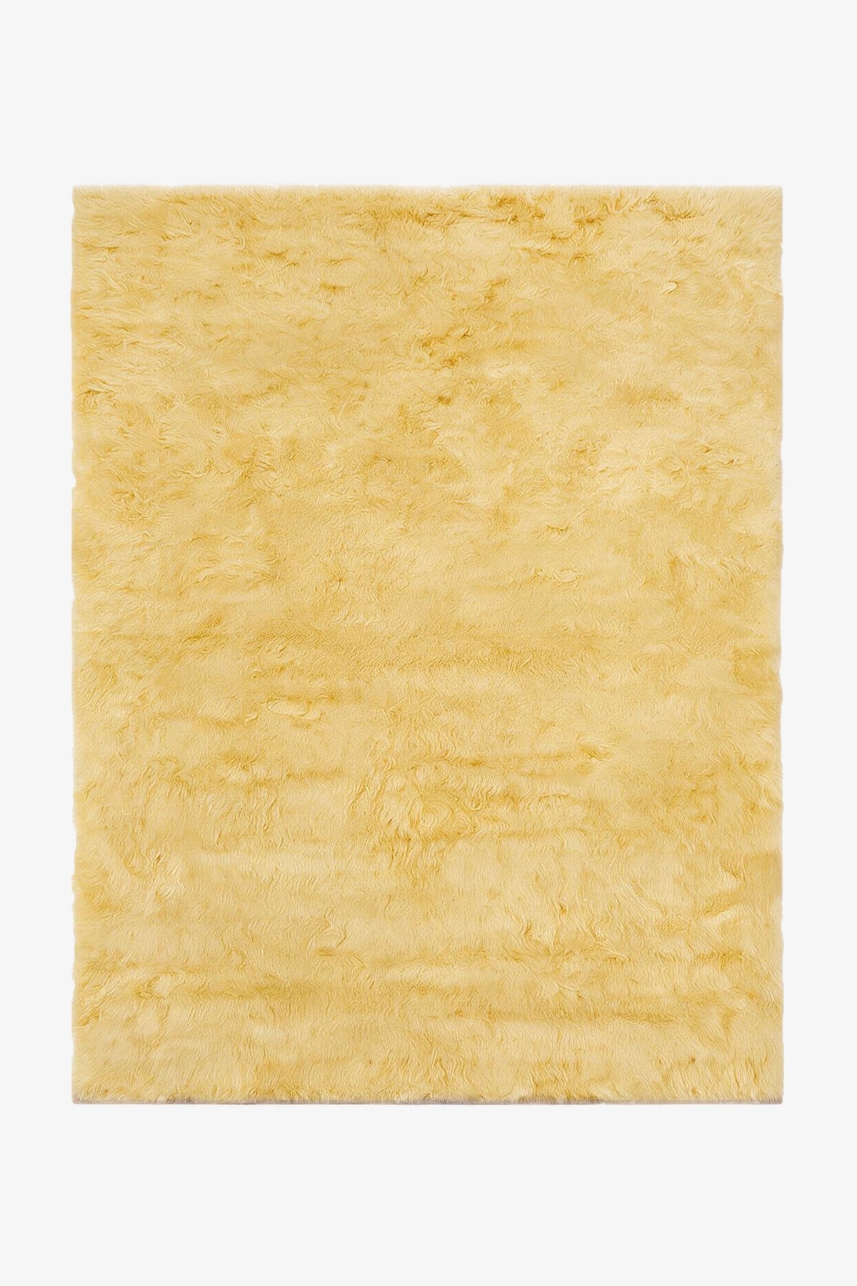 A rectangular pale yellow shaggy wool rug shown from a top-down view on a white background.