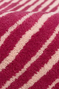 Close-up of a hot pink and white striped wool rug texture