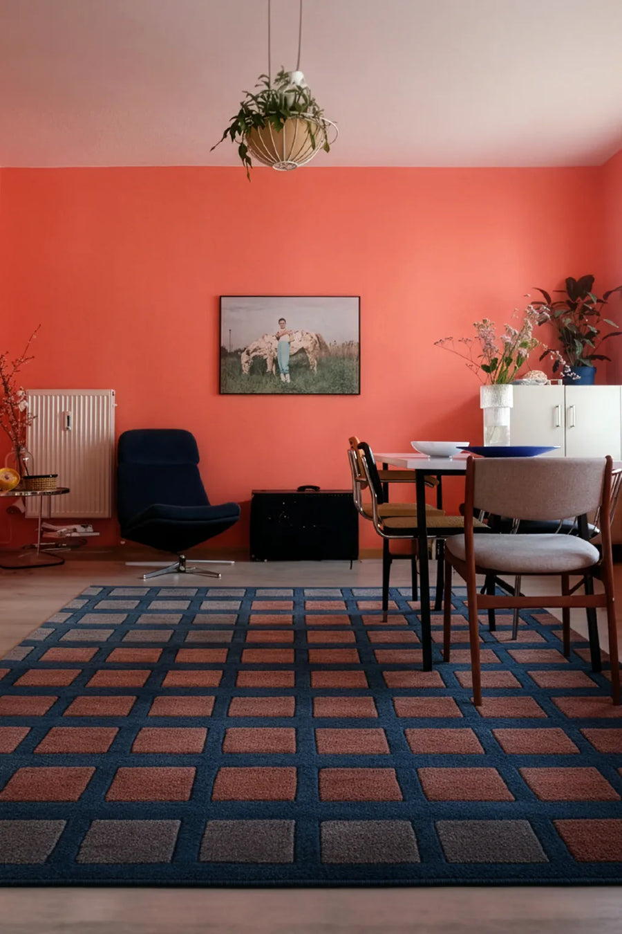 large deep teal rug with rust and gray squares in a modern southwestern living room lifestyle