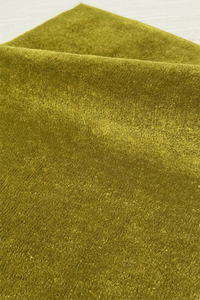 Close-up of green hand-tufted square rug texture
