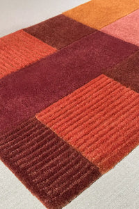 Modern 8x10 wool rug with earthy block design, terracotta and rust tones for living room or office