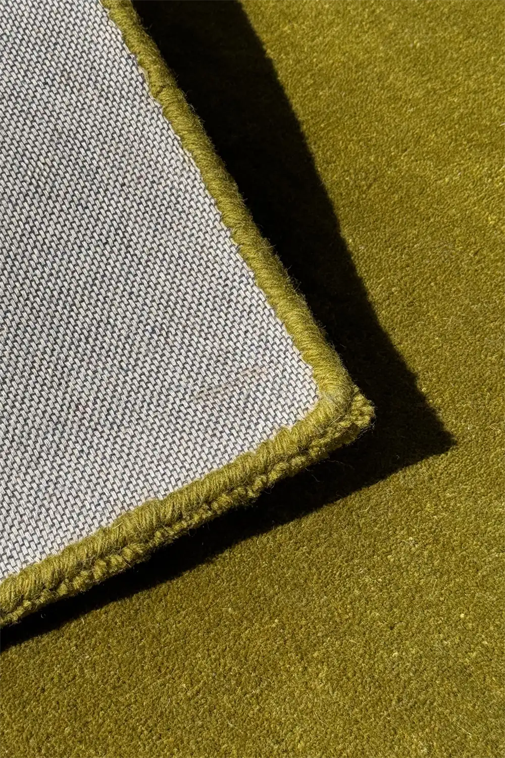 Close-up of a green rug with a textured edge