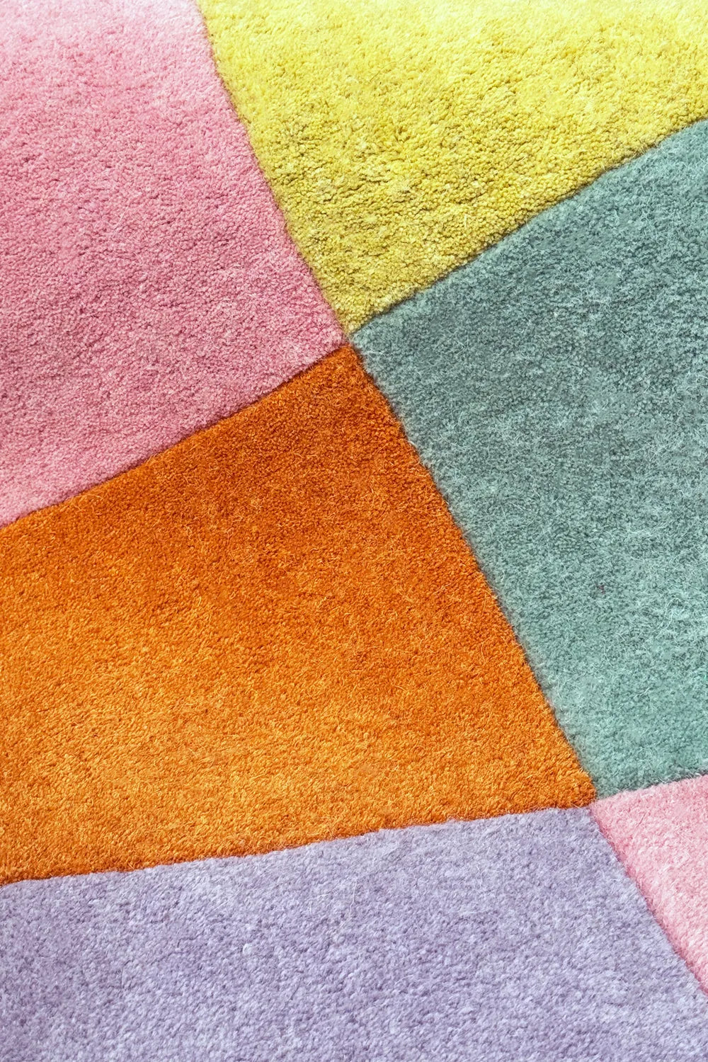 Close-up of colorful wool checkered rug with pastel and bright color blocks, thick plush texture
