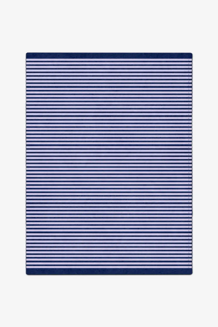 Navy and white striped rug on a plain background