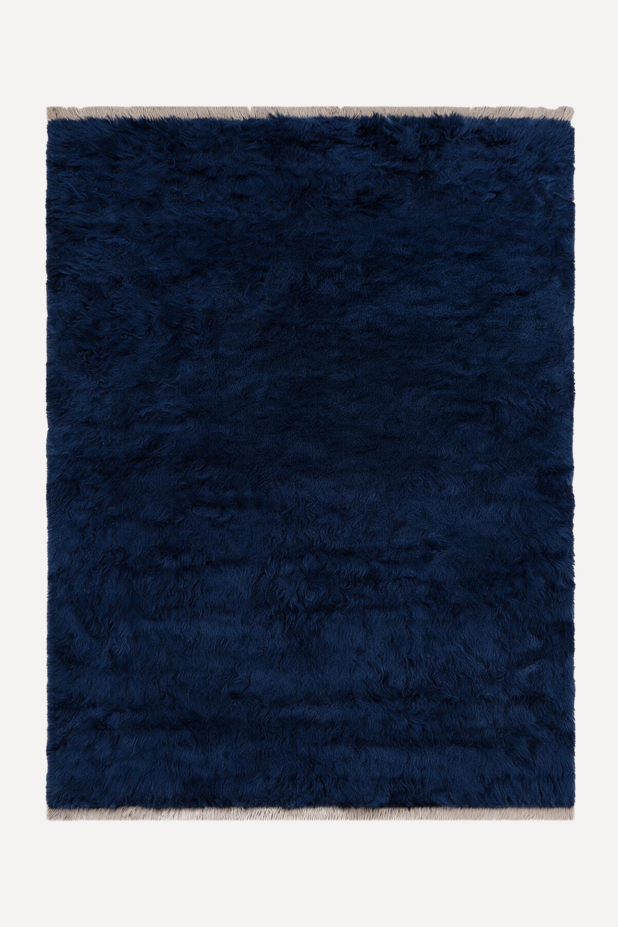 A dark navy blue shaggy area rug with light beige fringe on the top and bottom edges, shown flat against a light off-white background.