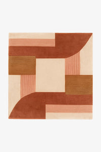 A square area rug with an abstract geometric pattern in terracotta, rust, peach, and cream, shown flat against a plain white background.
