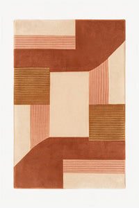 An abstract geometric area rug with a modern patchwork design in terracotta, dusty rose, tan, and cream, shown flat against a white background.
