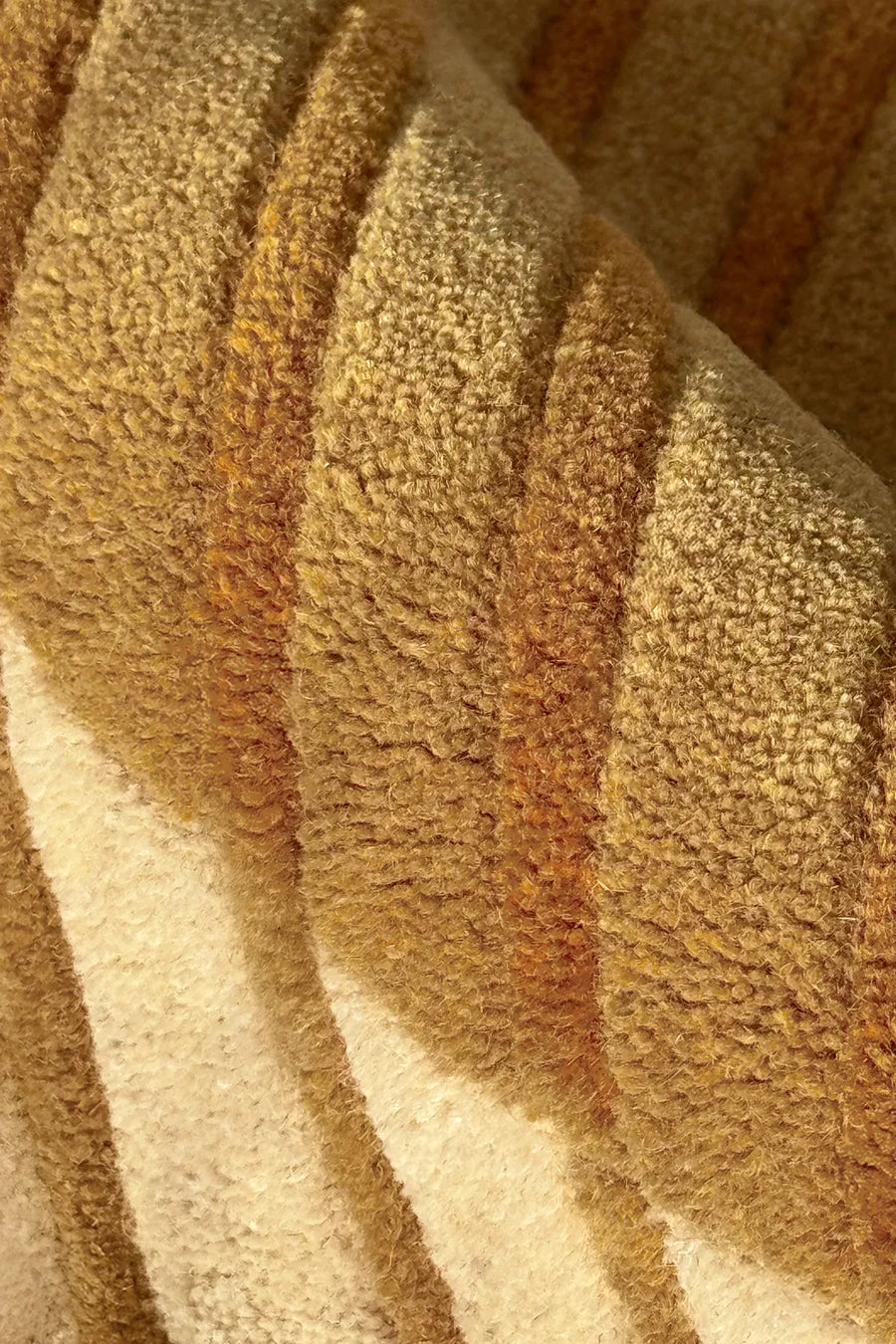 Close-up of plush golden yellow carved wool rug, highlighting the soft, hand-tufted texture and warm tonal striping