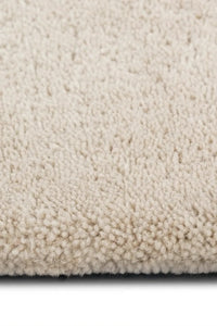 Detailed texture shot of cream high-pile wool rug, perfect for creating a soft natural soft rug feel in bedrooms
