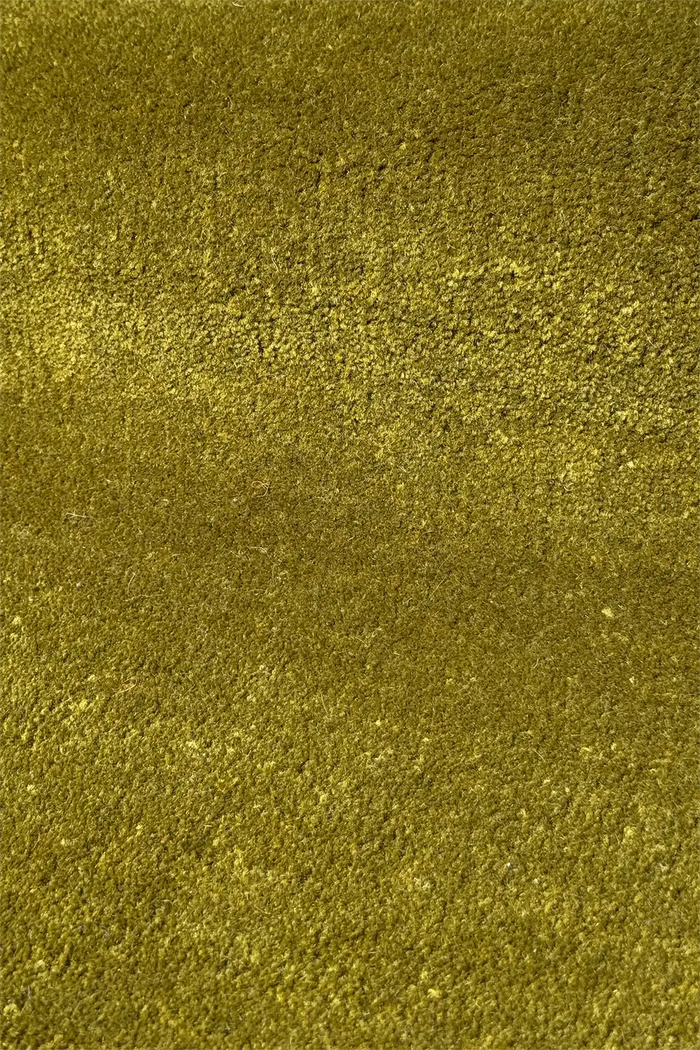 close up view of textured olive green hand tufted wool area rug
