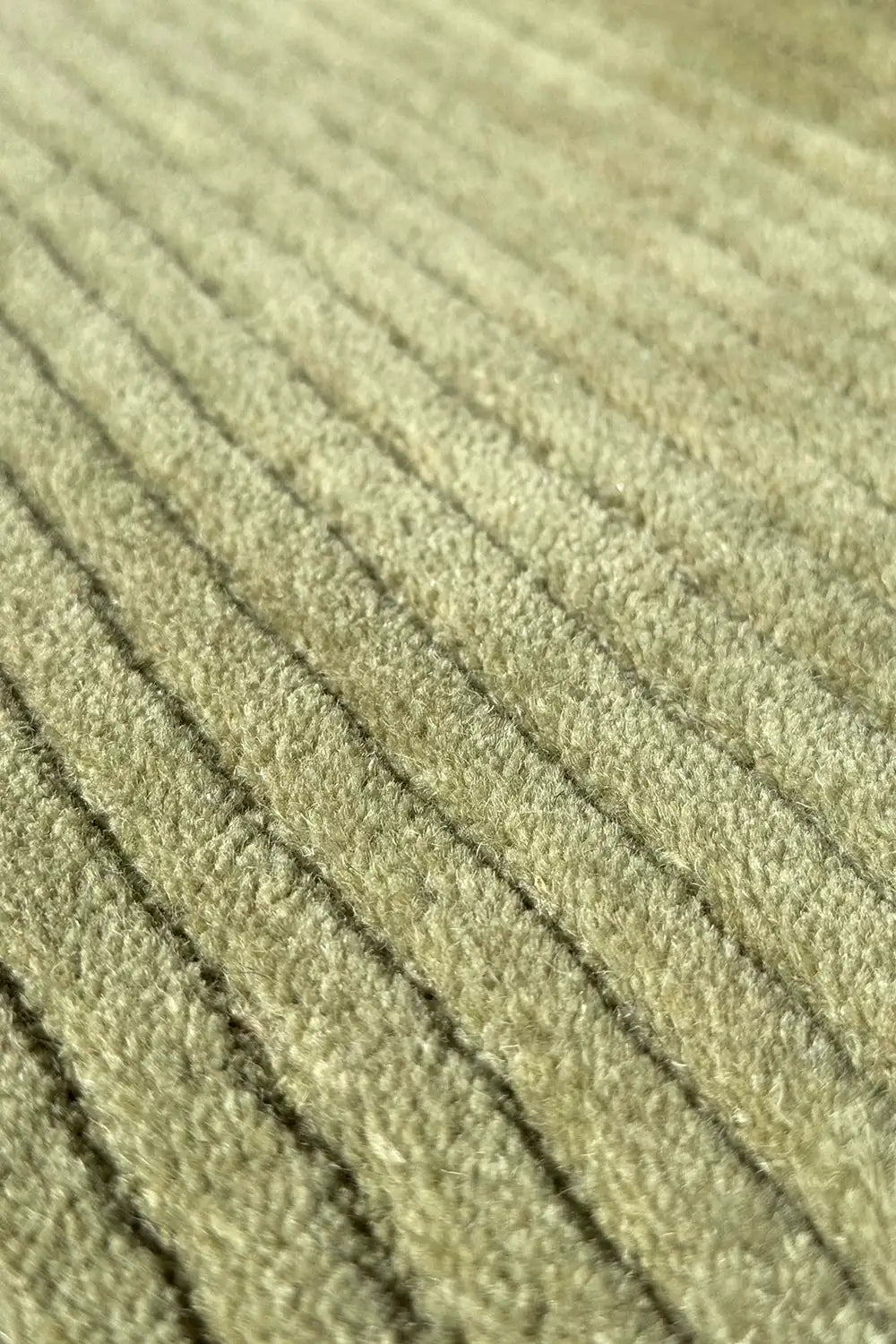 Textured olive green wool rug with soft ribbing and natural tone variation