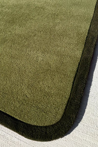 Olive green runner rug corner detail with bold dark trim, custom wool hallway rug