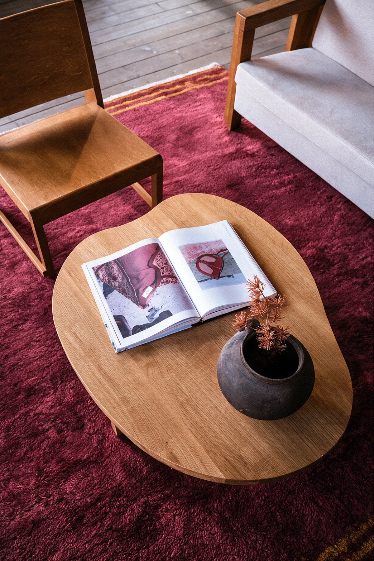 a warm living room with burgundy shaggy rug with gold stripes and a wooden table and chairs lifestyle