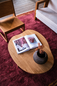a warm living room with burgundy shaggy rug with gold stripes and a wooden table and chairs lifestyle