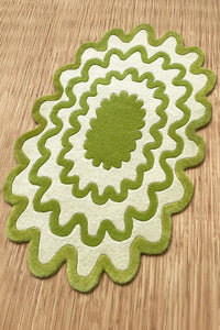 Hand-tufted wavy lime green rug with scalloped edges on a light wood floor, playful modern accent rug.