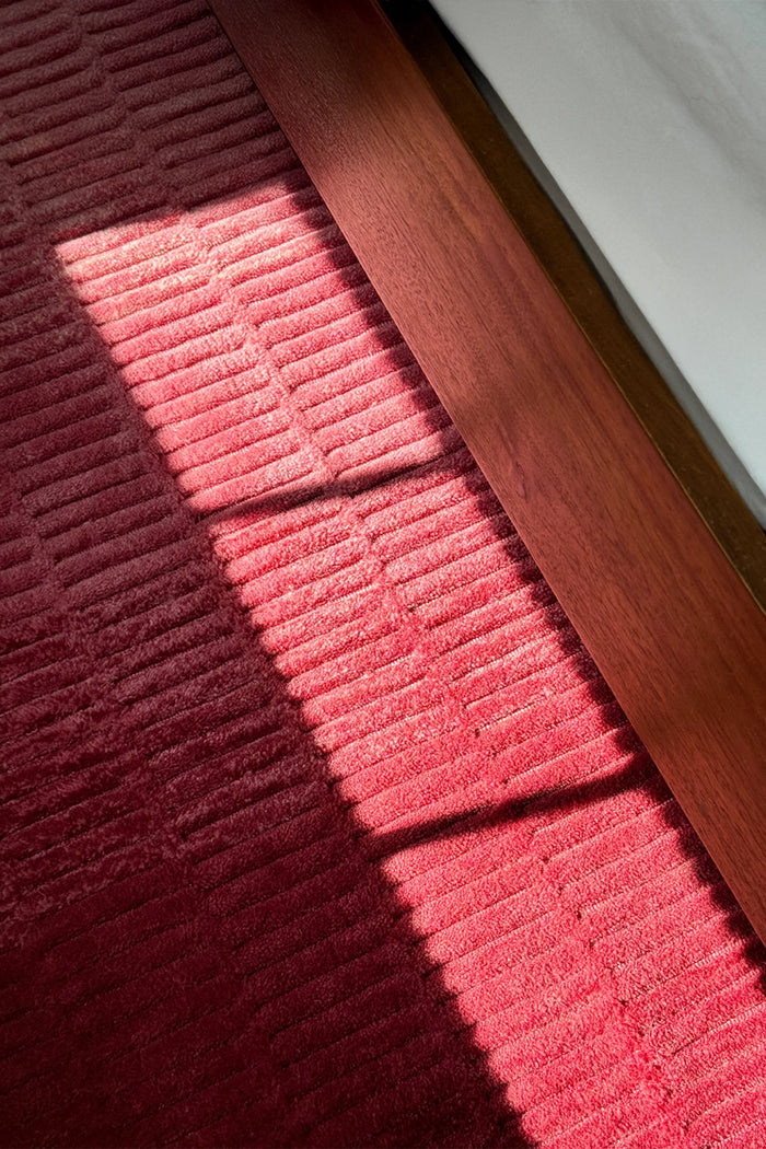 pink ombre runner rug next to a bed