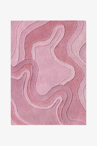 A rectangular area rug with an abstract, layered topographic pattern in shades of dusty pink and mauve, shown flat against a light gray background rose