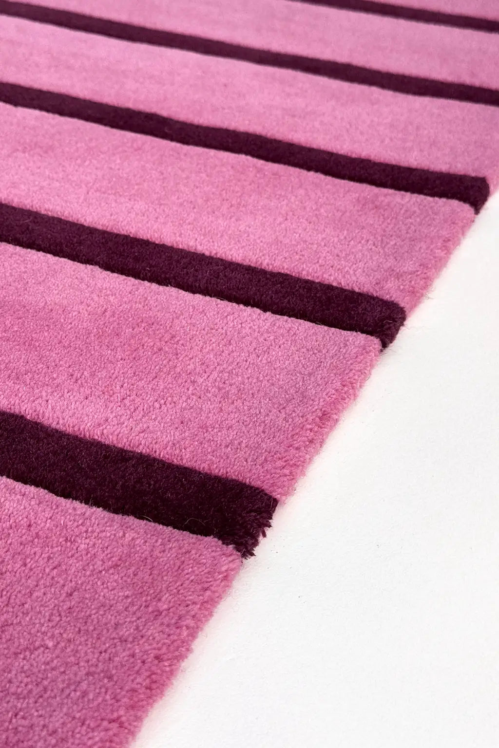 Close-up of a pink and purple striped extra long runner rug texture on a white background