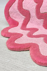 Close-up of textured pink and red modern wool rug with organic wave pattern