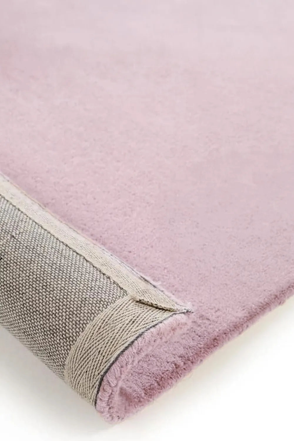Detailed view of baby pink hand-tufted wool rug with thick soft pile, great for cozy modern bedroom rugs