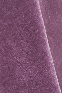 A close-up of textured mauve plum purple wool rug with a soft diagonal fold.