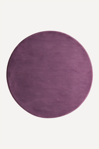 a plum purple round wool rug shown from above on a white background