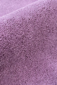 Solid purple wool rug texture close-up, soft modern area rug for bedroom or nursery