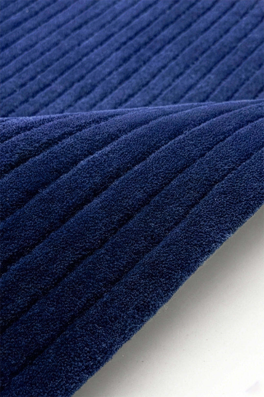 Close-up of blue textured rug with pleated pattern