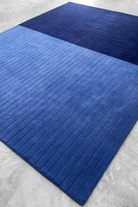 Blue textured rug on a gray floor