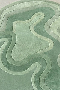 Sculpted sage green wool rug with flowing irregular lines and high pile texture