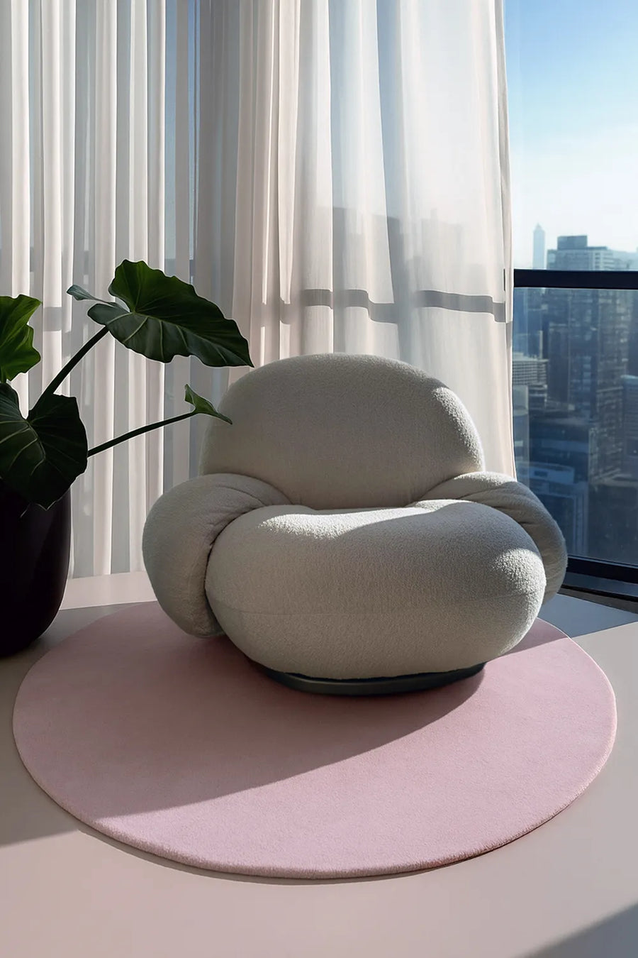 Soft pink round rug styled under modern lounge chair, available in custom sizes