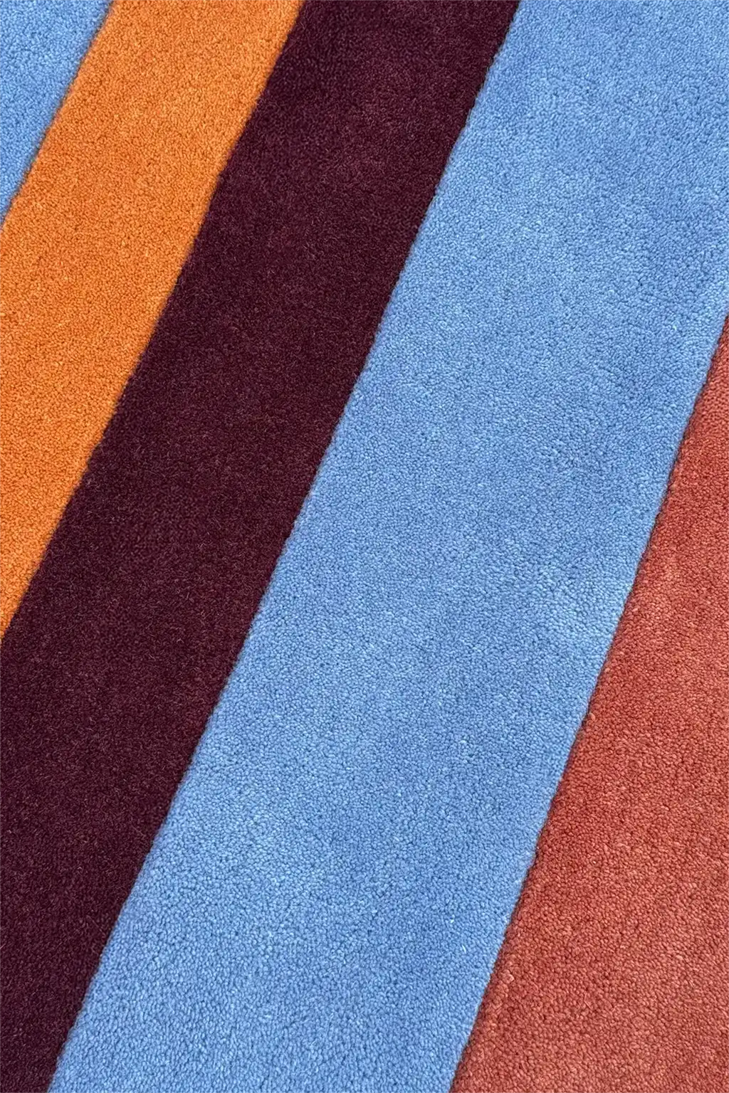 Close-up of a textured round rug with multicolored stripes.
