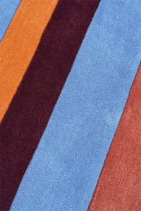 Close-up of a textured round rug with multicolored stripes.