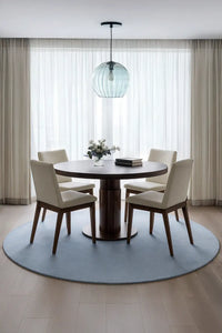 Modern 8ft round baby blue rug styled under a round dining table in bright minimalist dining room lifestyle