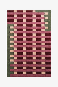 Rectangular wool rug with a geometric pattern in multi-colored red pink cream and green on a white background