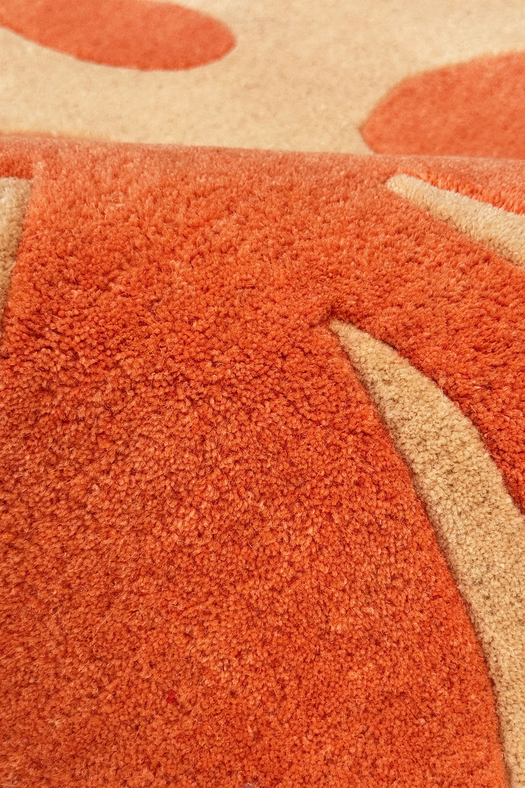 Close-up of a textured orange and beige runner rug with abstract patterns.