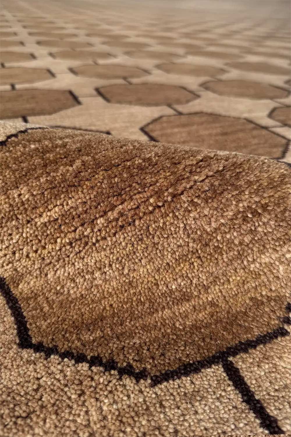 Close-up of a textured light taupe and beige wool rug with geometric pattern 