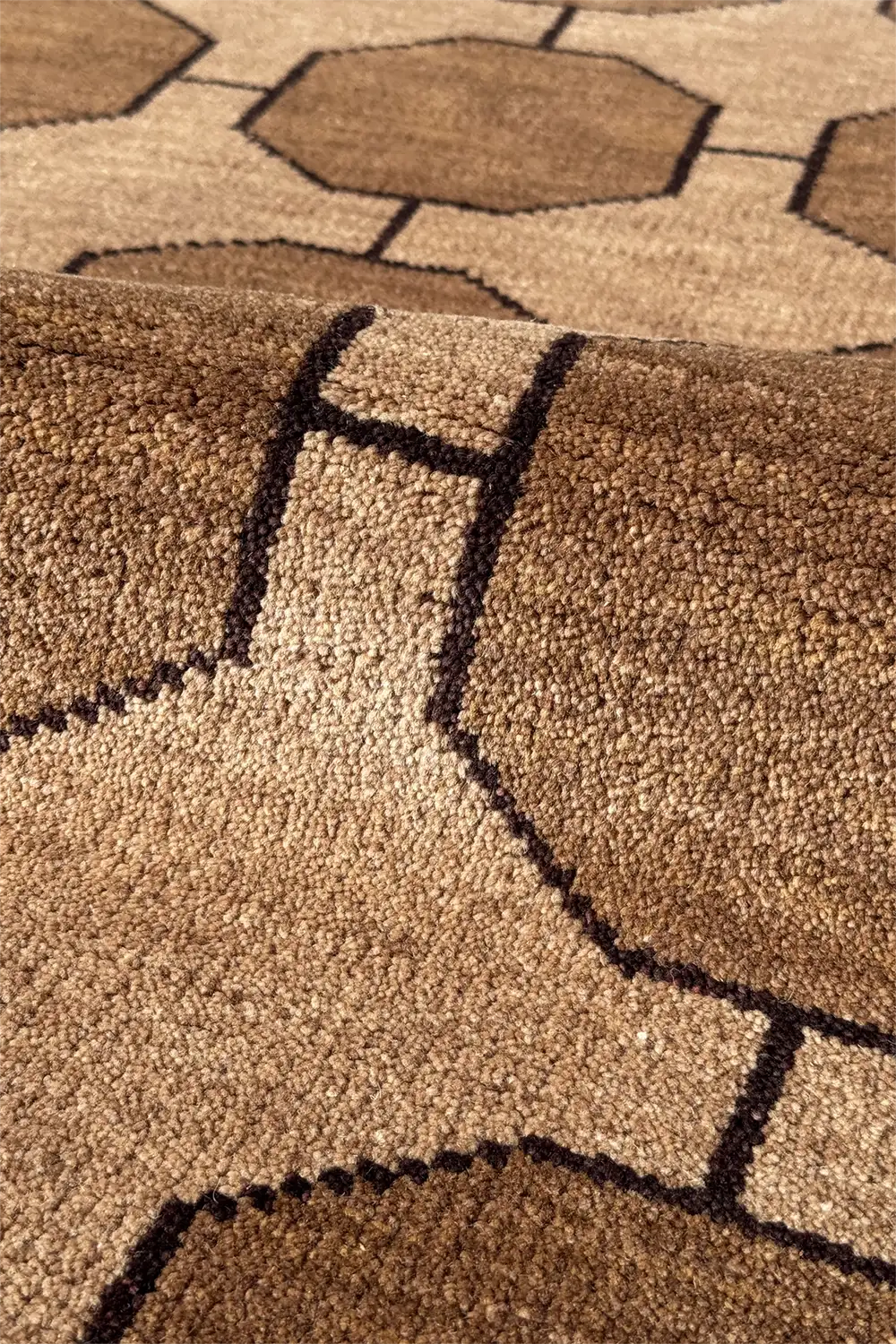 Close-up of a high quality wool brown textured rug with geometric pattern taupe