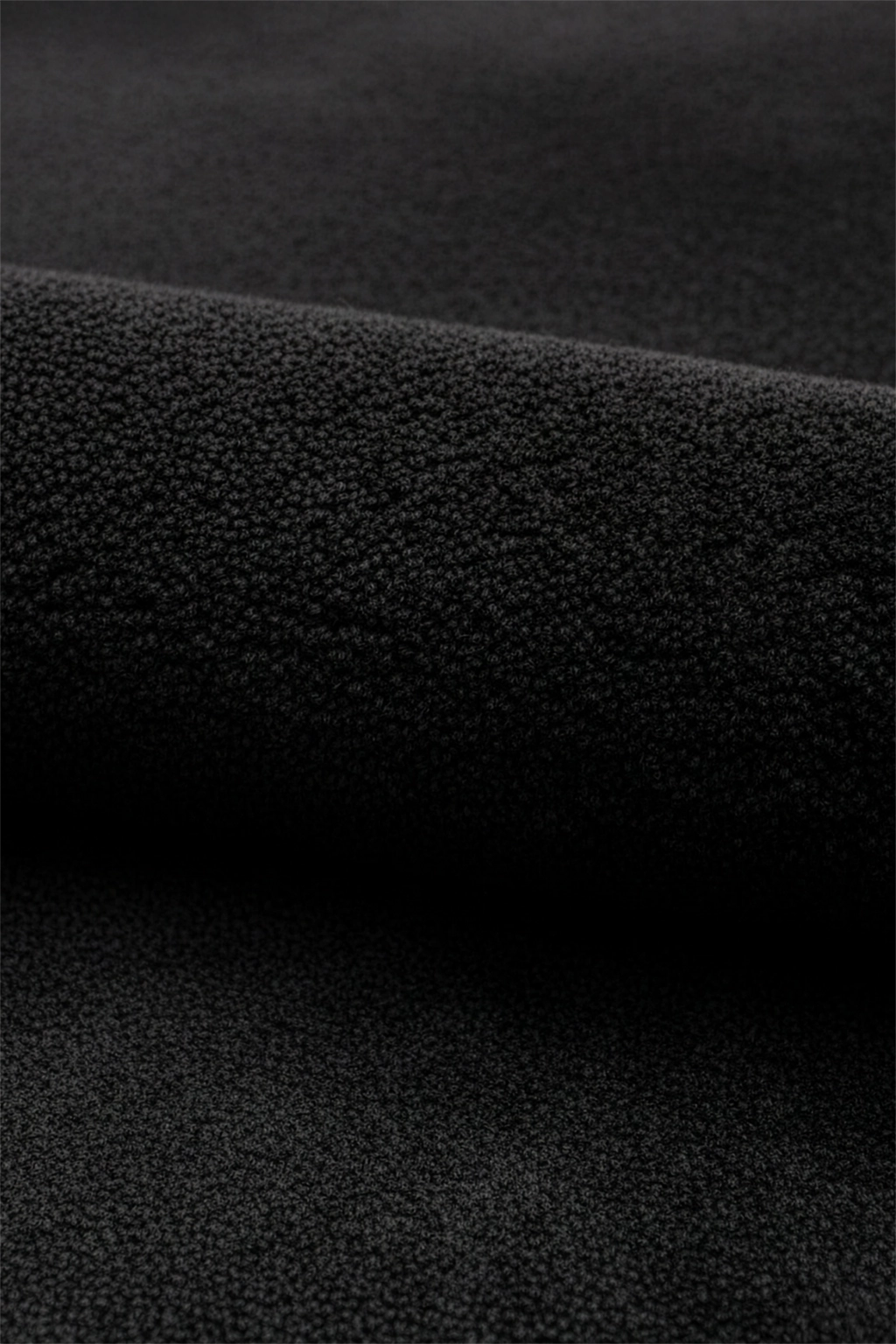 Close-up of black wool hand-tufted rug texture