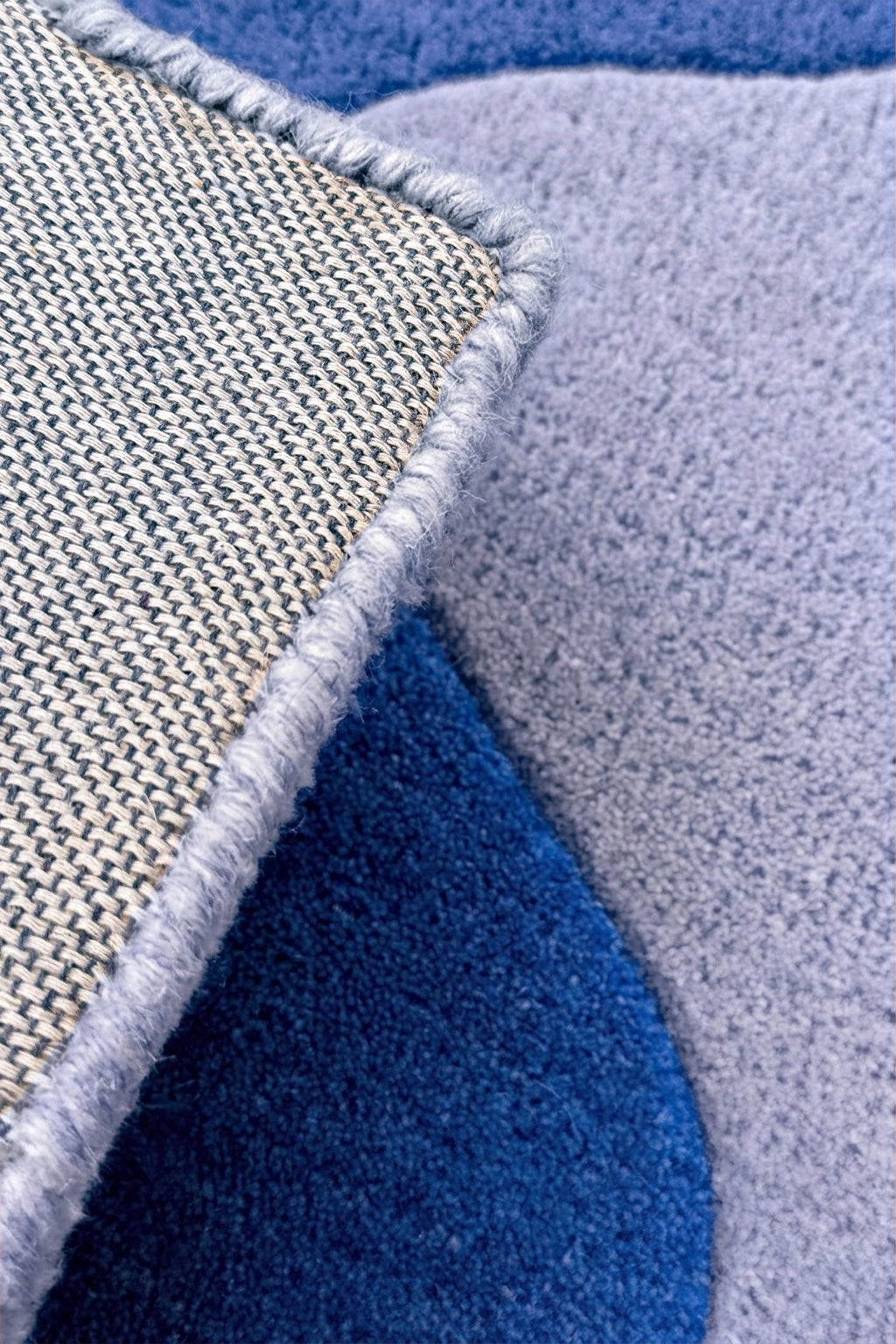 Close-up of textured rug with blue, gray, and beige colors.