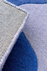 Close-up of textured rug with blue, gray, and beige colors.