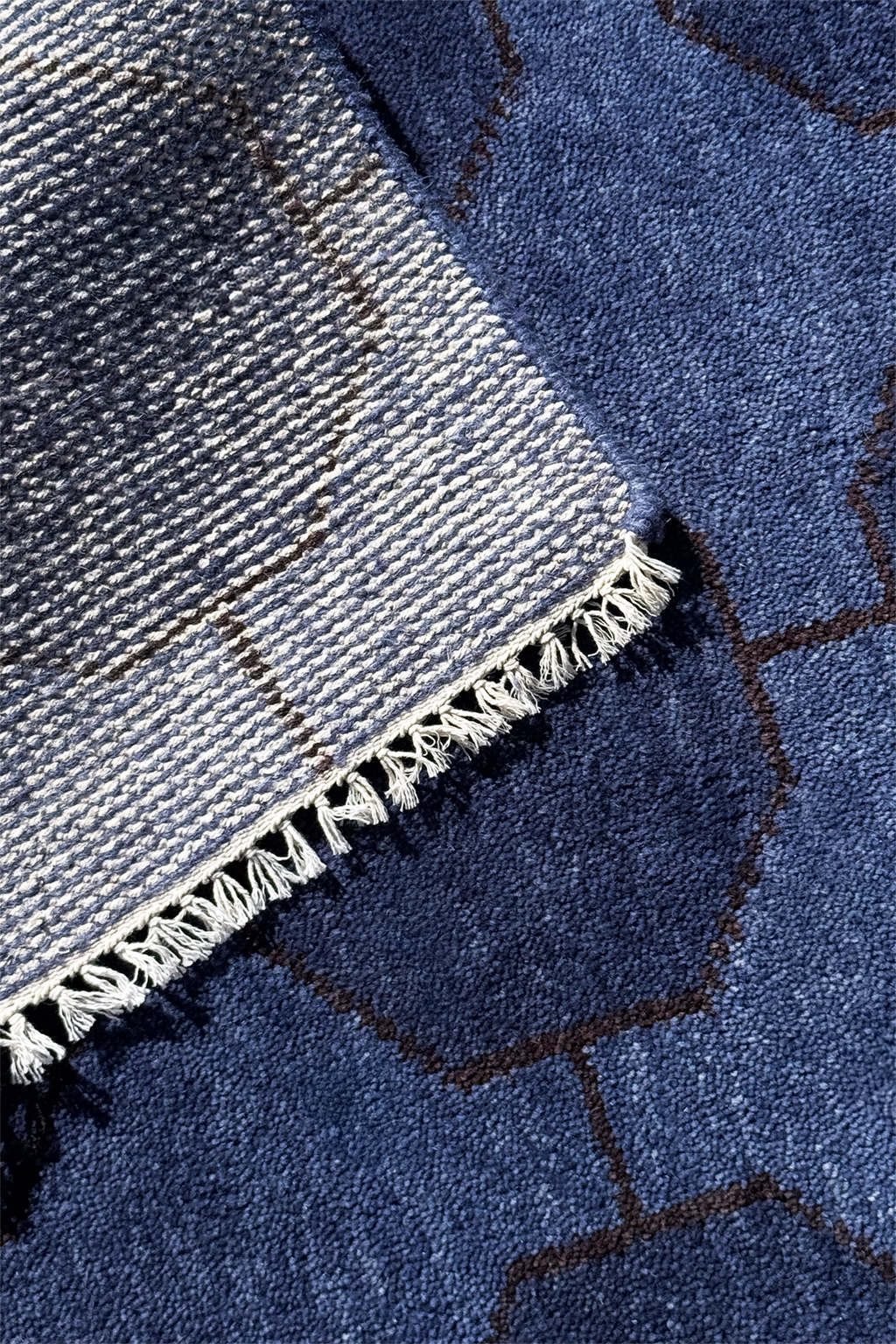 Close-up of a blue wool runner rug with white fringe