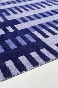 Close-up of a light blue and navy striped modern geometric patterned rug