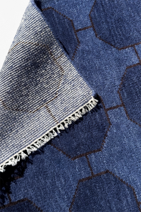 Close-up of a blue hand-knotted wool rug with geometric patterns