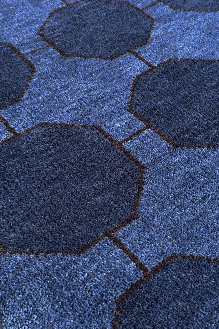 Close-up of a blue textured wool rug with geometric patterns