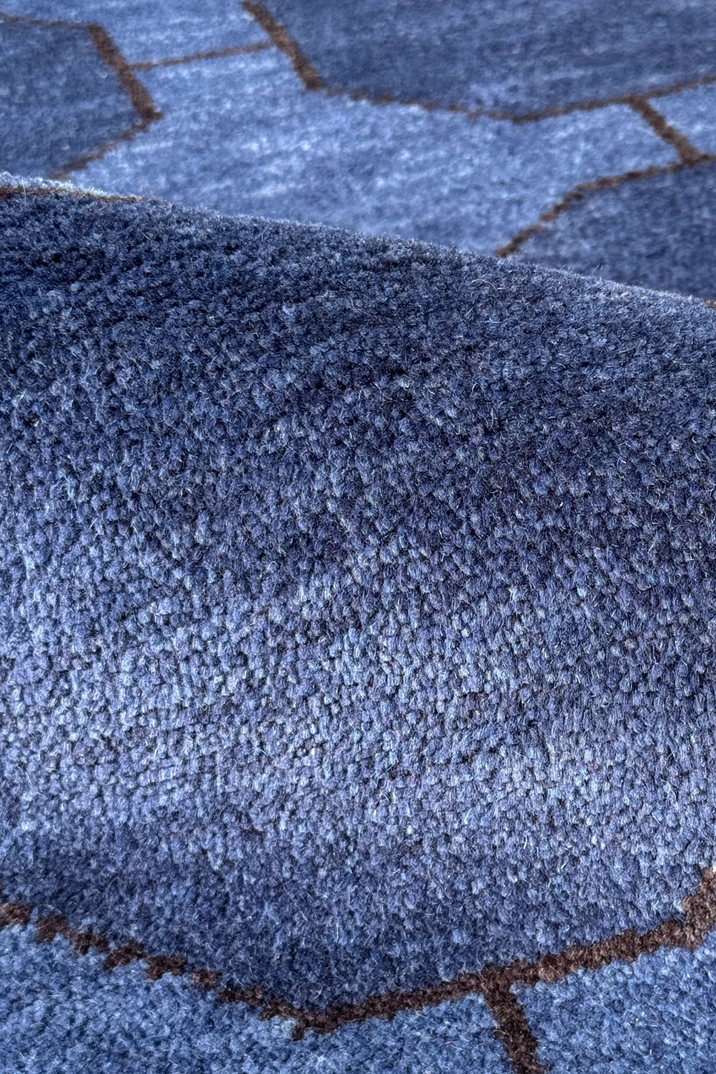 Close-up of a textured blue runner rug with geometric pattern