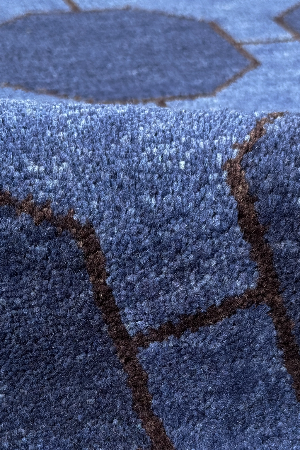 Close-up of a textured blue wool rug with geometric patterns
