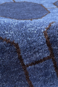 Close-up of a textured blue wool rug with geometric patterns
