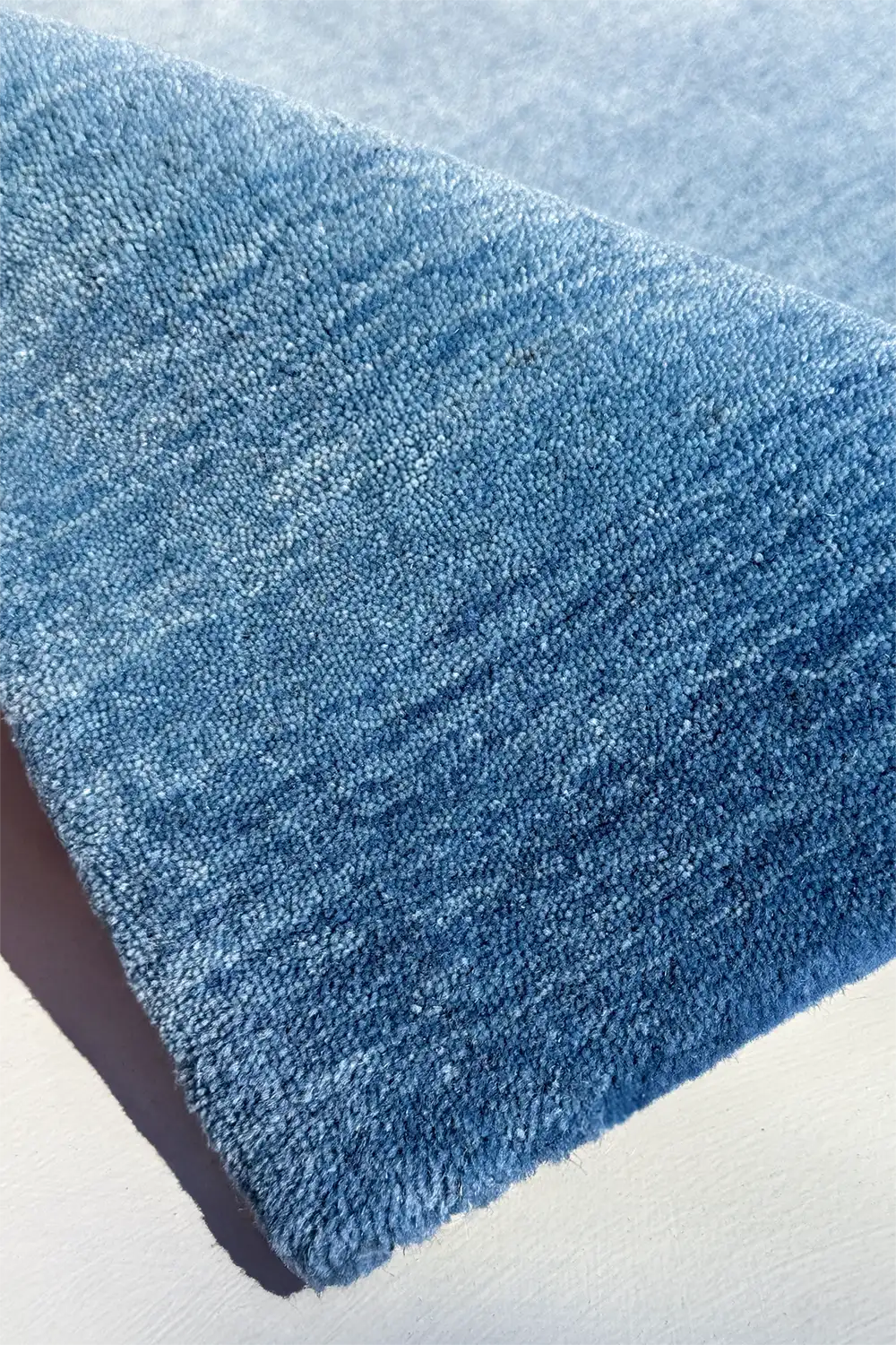 Blue ombre patterned textured rug on a light background